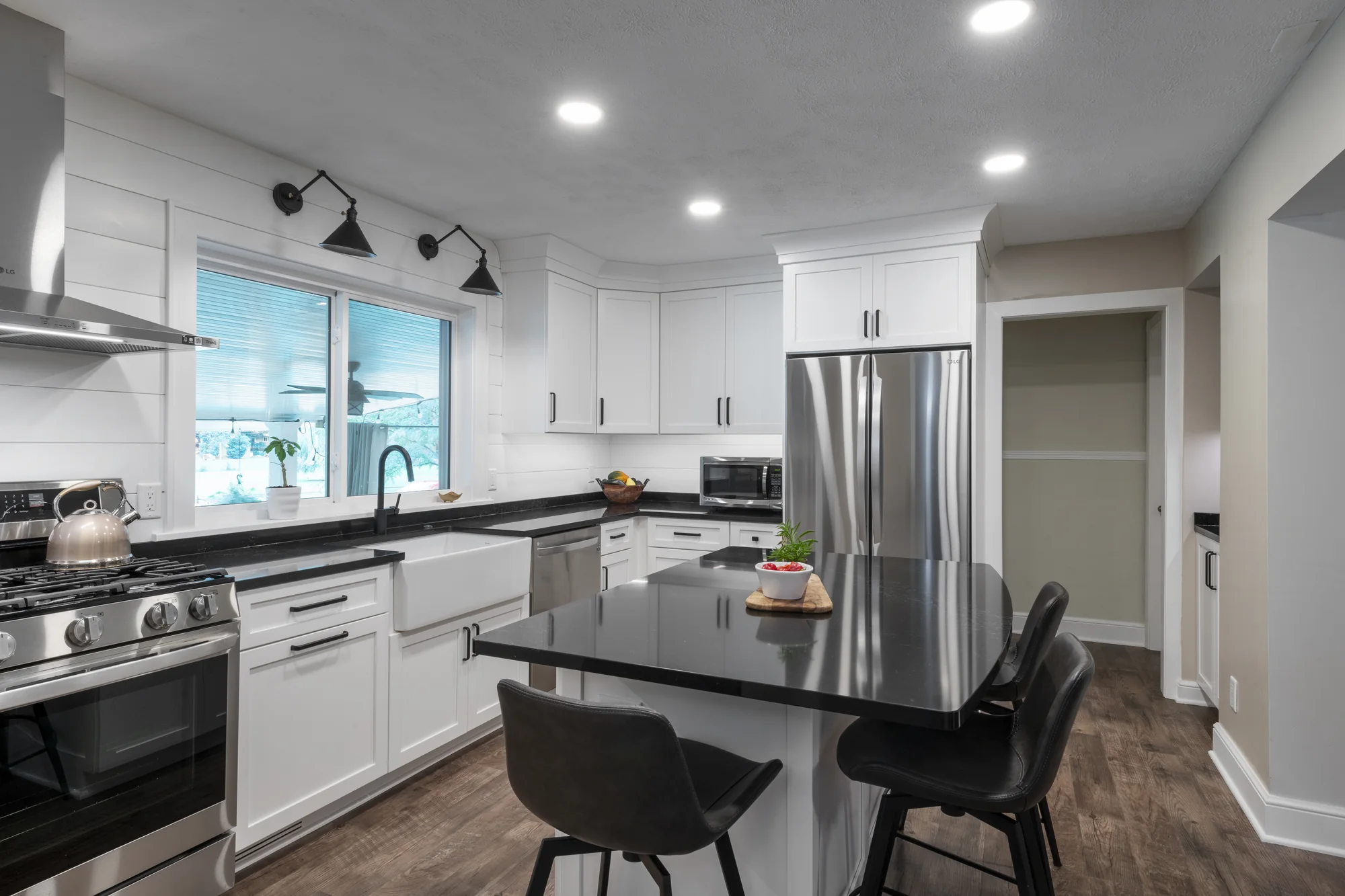 White modern farmhouse kitchen viewed across the island