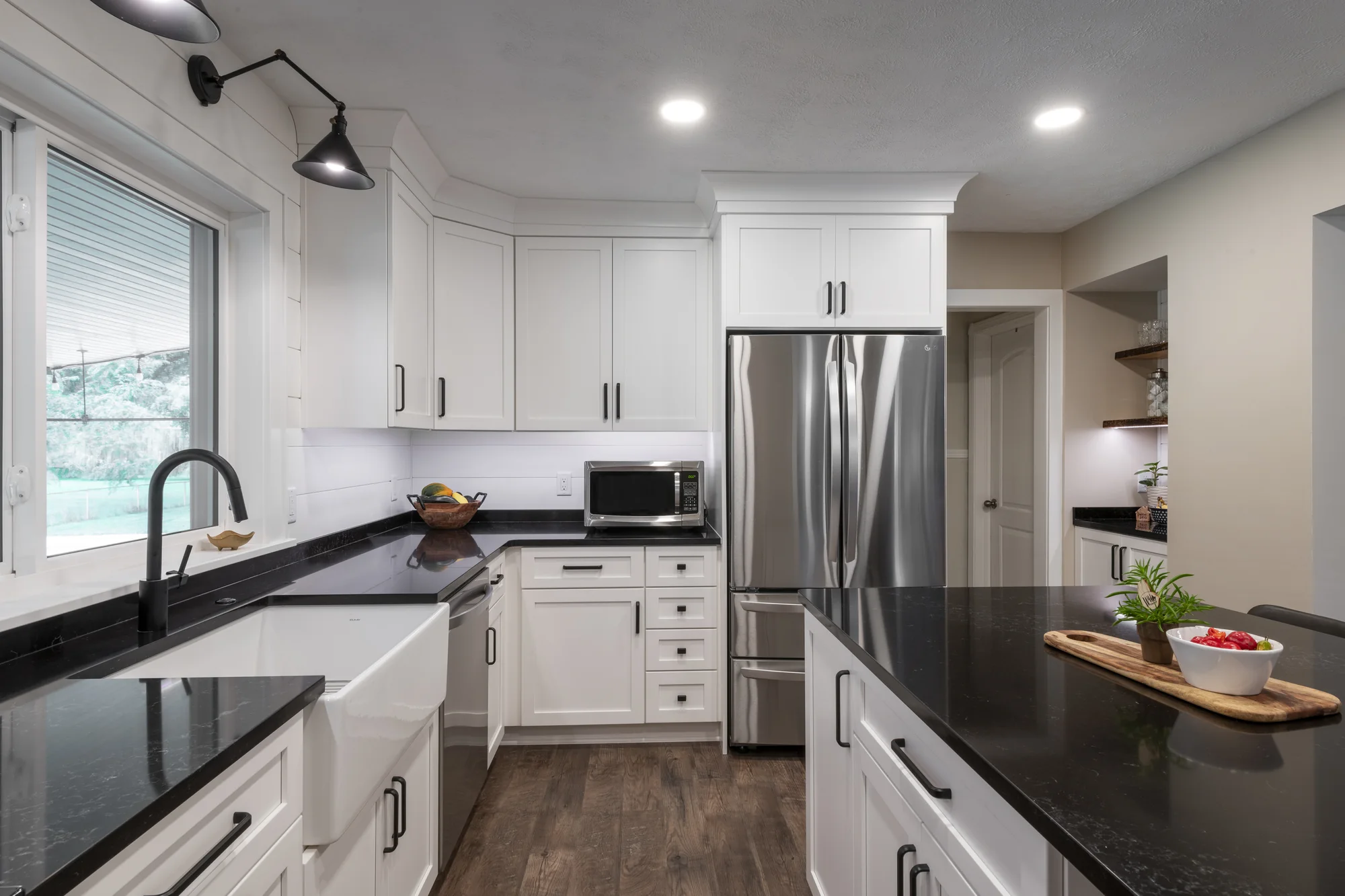 White cabinetry surrounding the sink and refrigerator