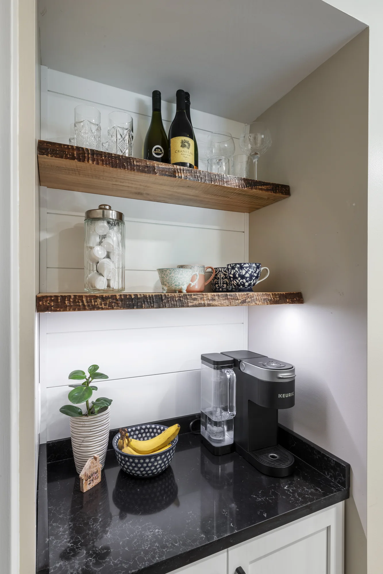 Built-in beverage area with wood shelves and white cabinetry
