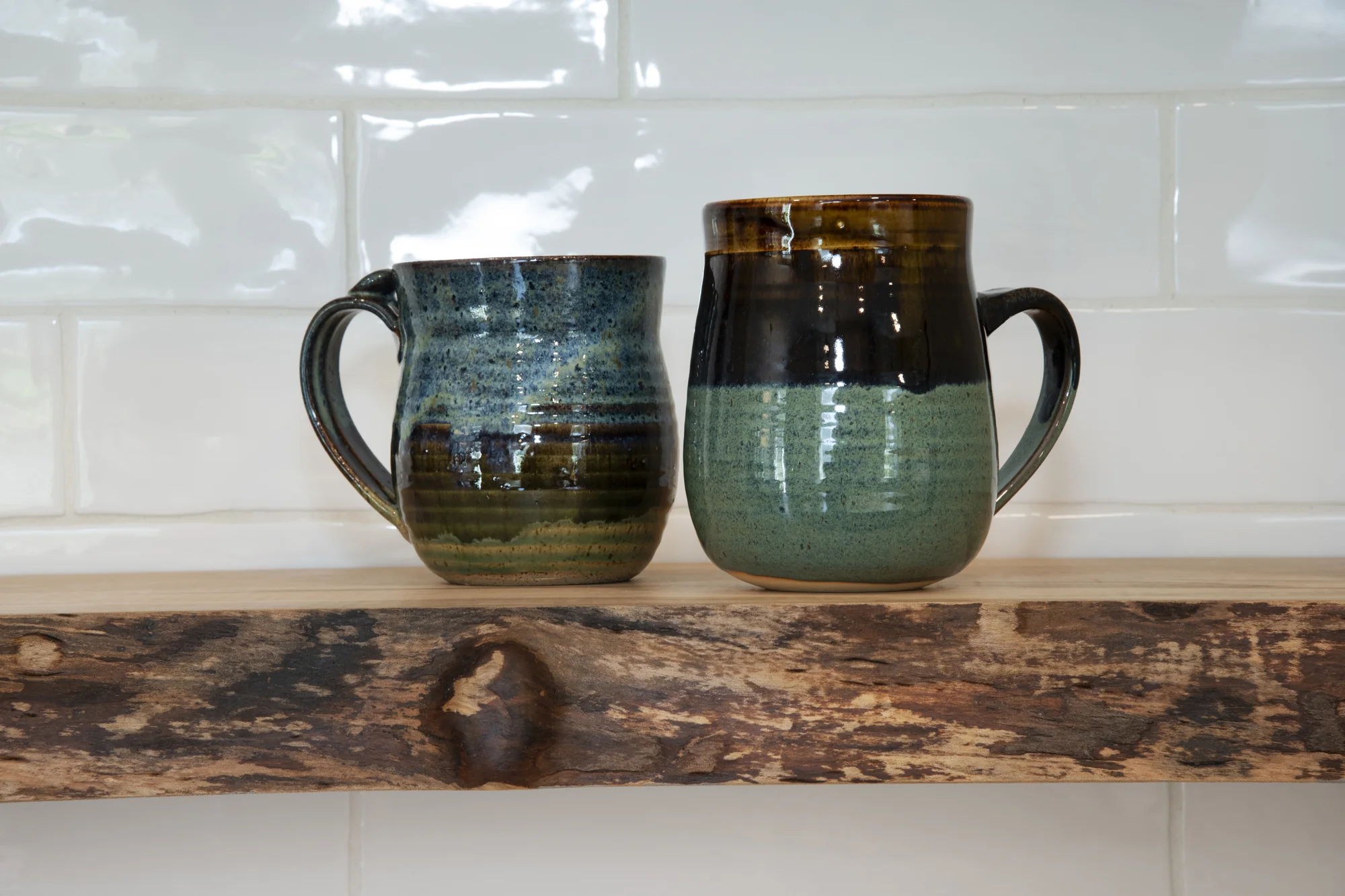 Handcrafted mugs displayed on a natural wood shelf